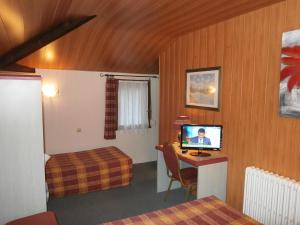 a hotel room with a bedroom with a tv and a bed at Hotel Beausejour in Rouen