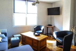 a living room with chairs and a table and a tv at Holiday Home in Bréhal near Sandy Beach in Bréhal