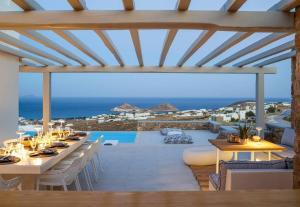 a dining room with a view of the ocean at Soleila Mykonos Villa in Kalafatis