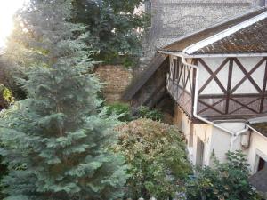 a christmas tree in a garden next to a building at Hotel Beausejour in Rouen