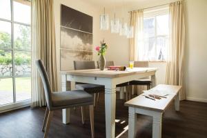 a dining room with a white table and chairs at Holiday house, Fuhlendorf in Fuhlendorf