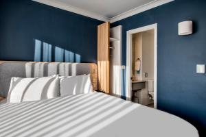 a bedroom with blue walls and a white bed at Holiday Inn Express Edinburgh City West by IHG in Edinburgh +38 photos