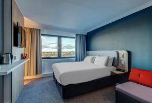 a hotel room with a bed and a large window at Holiday Inn Express Edinburgh City West by IHG in Edinburgh