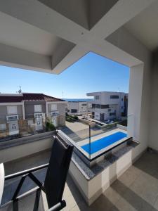 einen Balkon mit Poolblick in der Unterkunft Aquarius Luxury apartment with pool and sea view in Novalja