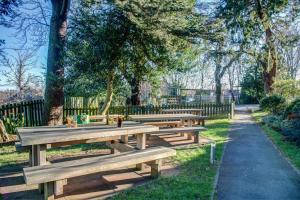 a row of wooden benches in a park at Holiday Inn Express Edinburgh City West, an IHG Hotel in Edinburgh
