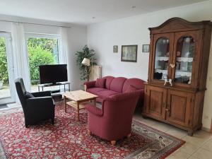 a living room with a couch and chairs and a table at Ferienwohnung Pewsum in Krummhörn