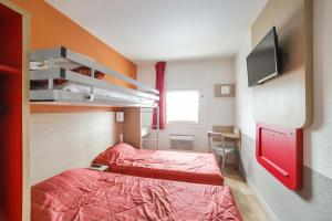 プレジールにあるPremière Classe Plaisir Gatinesのベッド2台とテレビが備わる小さな客室です。