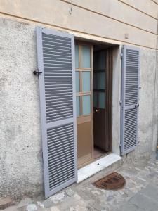 ein Fenster mit offenem Fensterladen neben einer Tür in der Unterkunft Casa vacanze P&G. Colline, mare, relax in La Spezia
