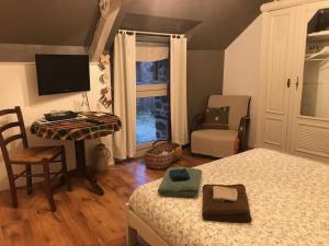 a bedroom with a bed and a desk with a computer at Chambre à la campagne in Québriac