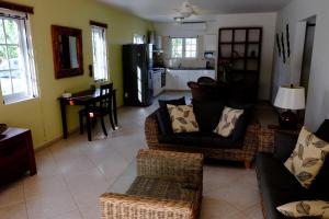 a living room with two couches and a kitchen at Villa Olivia Poolside in Kralendijk
