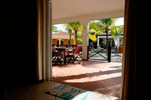 een open deur naar een patio met een tafel en stoelen bij Villa Olivia Poolside in Kralendijk