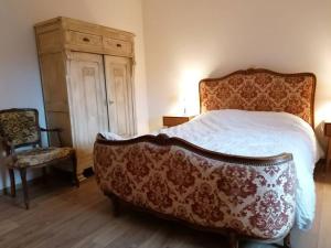 ein Schlafzimmer mit einem Bett, einer Kommode und einem Stuhl in der Unterkunft Gîte au coin perdu in Brugelette