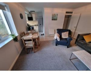 a living room with a blue chair and a table at Canal Side Retreat - 2 Bedroom Apartment in Heybridge