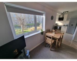 uma sala de jantar com uma mesa e uma grande janela em Canal Side Retreat - 2 Bedroom Apartment em Heybridge