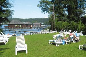 a bunch of chairs sitting on the grass by the water at Apartment in St Kanzian am Klopeinersee with garden in Wasserhofen