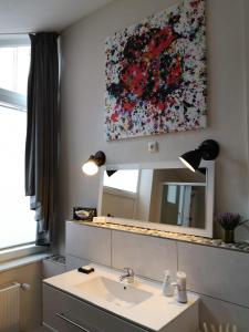 een badkamer met een wastafel en een schilderij aan de muur bij Denkmal in Melsungen