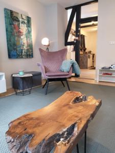 een houten salontafel in een kamer met een stoel bij Denkmal in Melsungen