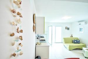 una cocina blanca con conchas en la pared en Seashell Vinjerac, en Vinjerac
