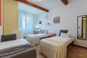 2 letti in una camera con pareti bianche di Central Ferrara Apartment a Ferrara