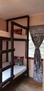 a room with two bunk beds and a window at Mambo & Jambo Homestay in Mwanza