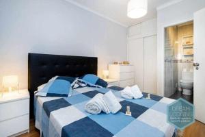 uma cama azul e branca com toalhas em Forte 303 Dream Lodging em Albufeira