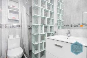 uma casa de banho branca com um WC e um lavatório em Forte 303 Dream Lodging em Albufeira