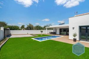 a backyard with a green lawn and a swimming pool at Casa do Alto Dream Lodging in Albufeira