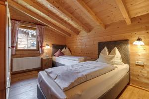 a bedroom with two beds in a wooden cabin at Chalets Almdorf Zillertal, Fügen in Fügen