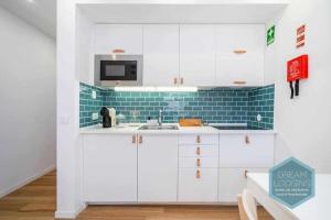 uma cozinha branca com um lavatório e um micro-ondas em Vila Magna 603 Dream Lodging em Albufeira