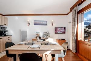 een eetkamer met een houten tafel en stoelen bij Family Apt With Superb View On The Mont Blanc in Les Houches