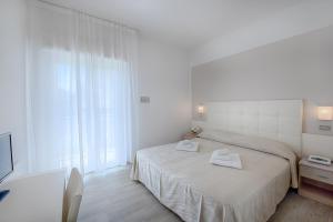 a bedroom with a bed with two towels on it at Hotel Sanremo in Milano Marittima +20 photos