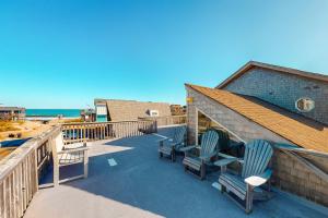 a deck with chairs and the ocean in the background at Zen Den #18-B in Buxton