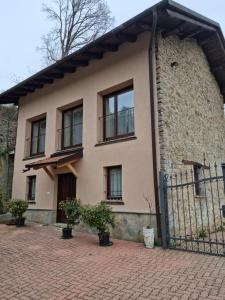 a house with a gate and a brick building at LANGHE PARADISOT in Niella Belbo