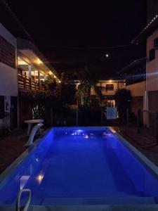 a large blue swimming pool at night at Pousada Baleia Franca in Garopaba