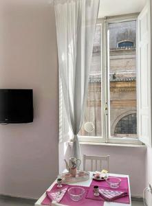 ローマにあるLoft Campo de' Fiori - Appartamento Campo de' Fiori - LE CUGINEのピンクのテーブルクロスと窓