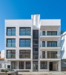 Un edificio de apartamentos con fachada blanca y negra. en Doña Elvira Malasaña, en Málaga