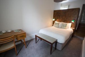 a bedroom with a bed and a table and a desk at The High Field Town House in Birmingham