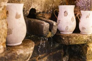 quatro vasos brancos sentados numa parede de pedra em Casa Brandariz em Santa Maria de Arzua