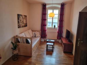 a living room with a couch and a window at Vila Lucia - Apartmán 3 in Pilsen