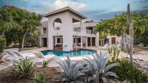 una vista exterior de una casa con piscina en Coral Estate Villa 19 - architectural eye-catcher with private pool, en Willibrordus