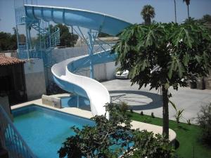 uno scivolo in una piscina accanto a una piscina di Mansion Serrano Hotel a El Fuerte