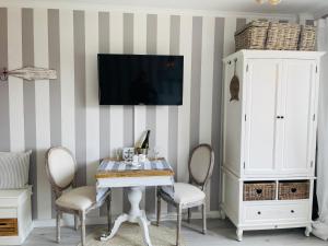 a dining room with a table and chairs and a tv at Moin Grömitz in Grömitz