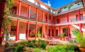 une vue sur l'extérieur d'un bâtiment avec colonnes rouges dans l'établissement Hotel Villa Antigua, à Sucre