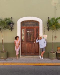 a man and a woman standing in front of a door at Kuka y Naranjo in Mérida