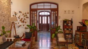 a living room with a wooden door and a room with plants at Kuka y Naranjo in Mérida