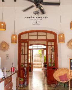 a room with a table and chairs and a clock on the wall at Kuka y Naranjo in Mérida