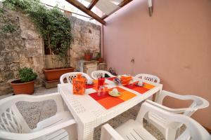 - une table et des chaises blanches sur la terrasse dans l'établissement B&B Zì Micheli Salento, à Castrignano del Capo