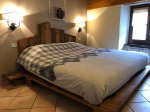uma cama num quarto com uma moldura de madeira em Appartamenti vista Monte Bianco Courmayeur-Entrèves em Entrèves