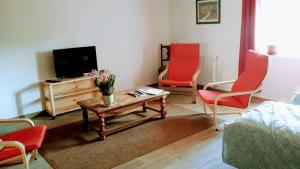 salon z czerwonymi krzesłami i telewizorem w obiekcie Casa Arnera w Andon