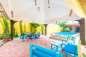 a patio with blue chairs and a swimming pool at Malecon Beach House in Progreso 1 block from beach in Progreso